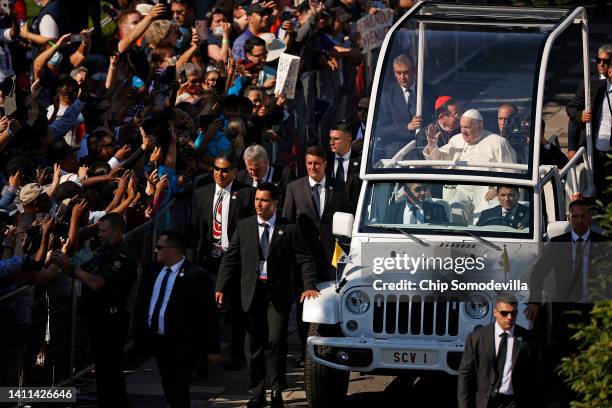 Pope Francis greets supporters from the "Popemobile" as he arrives at the National Shrine of Sainte-Anne-de-Beaupre to celebrate mass on July 28,...