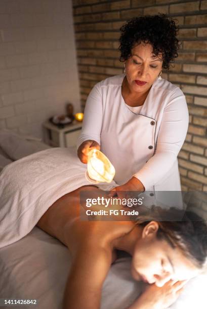 masseuse pouring oil on customer's back - wax figure stock pictures, royalty-free photos & images