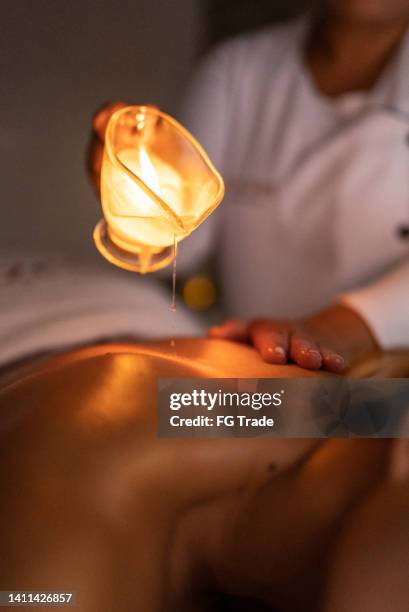 masseuse pouring oil on customer's back - images of brazilian wax 個照片及圖片檔