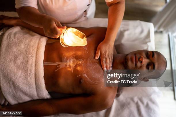 masseuse pouring oil on customer's back - images of brazilian wax 個照片及圖片檔