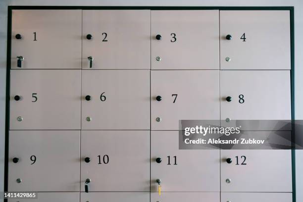 a closed metal locker with a key and a key tag in the office. the lock of the filing cabinet with a key. security and security system in a public institution. individual confidential locker, luggage storage in a hostel or coworking. - locker room wall stock pictures, royalty-free photos & images