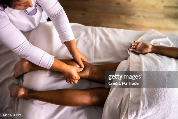 terapeuta de masaje masajeando a una mujer en un spa de belleza - black massage therapist fotografías e imágenes de stock