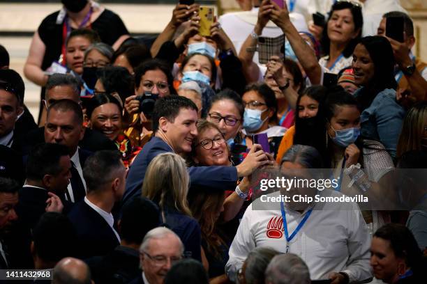 Canadian Prime Minister Justin Trudeau poses for selfies with Indigenous people who are attending mass with Pope Francis at the National Shrine of...