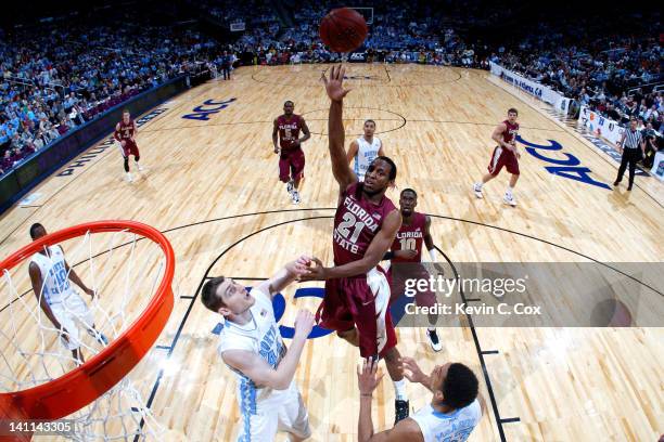 Michael Snaer of the Florida State Seminoles shoots over Tyler Zeller and James Michael McAdoo of the North Carolina Tar Heels during the Final Game...