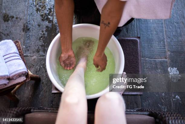 美容院で女性に足湯を漕ぐ美容師 - bath salt ストックフォトと画像