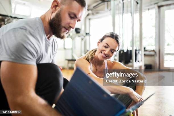 entrenador que planifica el entrenamiento deportivo con su cliente - entrenador personal fotografías e imágenes de stock