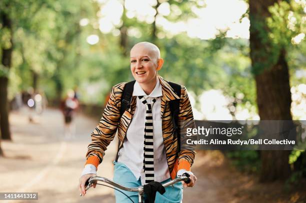 young woman biking through a park - showus 個照片及圖片檔