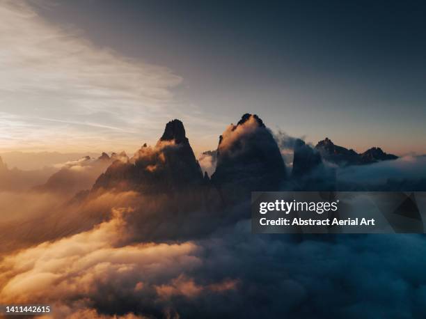 tre cime di lavaredo surrounded by clouds on a summers evening seen from a drone, dolomites, italy - 威納托省 個照片及圖片檔
