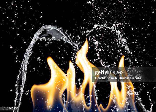 fire fighting sprinkler head, drops of pressurized water from a fire extinguisher fall on the flames of a fire. - extinguir fotografías e imágenes de stock