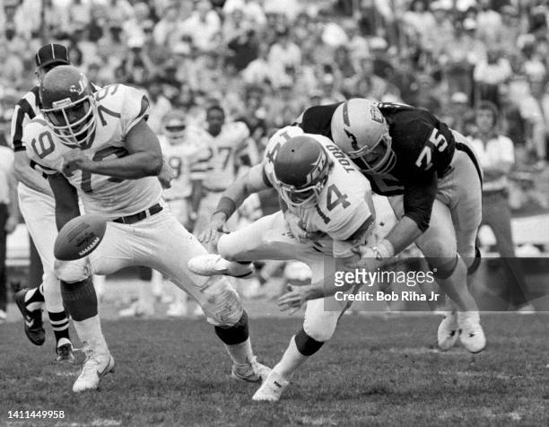 New York Jets QB Richard Todd fumbles football after being hit by Raiders Howie Long during AFC Playoff game, January 15, 1983 in Los Angeles,...