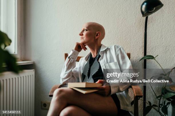 woman daydreaming by the window - hair loss stock pictures, royalty-free photos & images