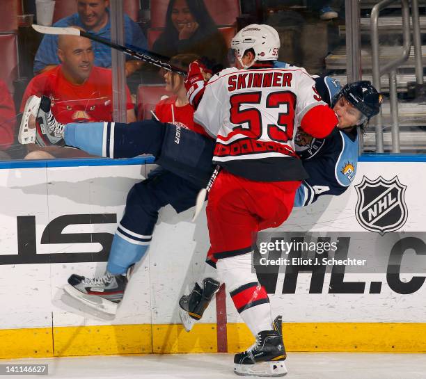 Keaton Ellerby of the Florida Panthers is checked into the boards by Jeff Skinner of the Carolina Hurricanes at the BankAtlantic Center on March 11,...