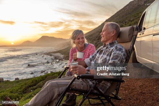 senior couple enjoying sunset by the sea - pensionär bildbanksfoton och bilder