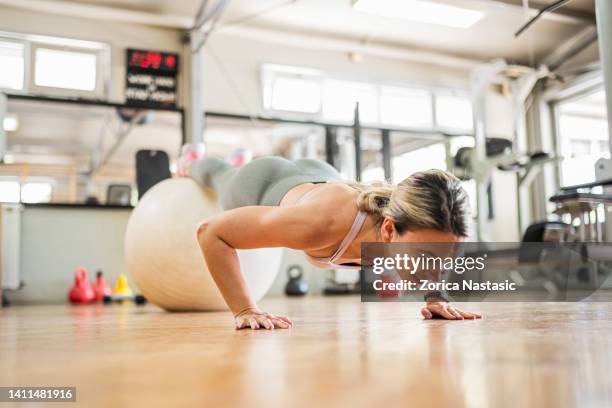 hermosa mujer entrenando pilates con pelota de fitness en gimnasio - abs miss fotografías e imágenes de stock
