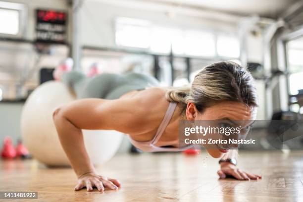 mujer joven entrenando pilates con pelota de fitness - abs miss fotografías e imágenes de stock
