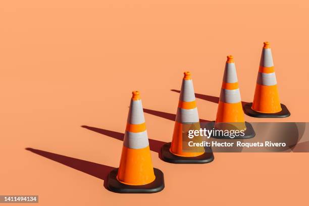 3d render of many traffic cones on orange background - kegel stock-fotos und bilder
