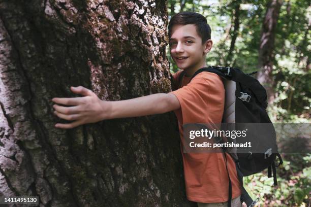 happy boy hugging a tree - tree hugging stock pictures, royalty-free photos & images