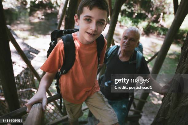 grand-père et petit-fils escaladant une tour de guet dans la forêt - tour de guet photos et images de collection