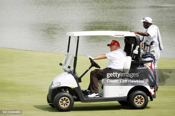 Former U.S. President Donald Trump drives his cart on the 18th hole during the pro-am prior to the LIV Golf Invitational - Bedminster at Trump...