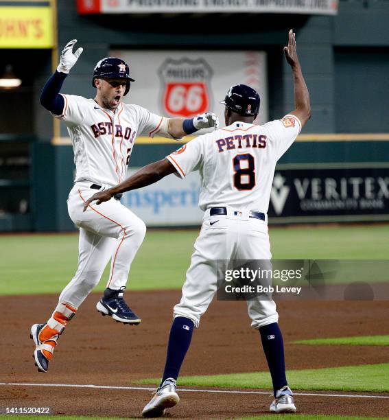 Alex Bregman of the Houston Astros is congratulated by Gary Pettis after hitting a two-run home run in the first inning against the Seattle Mariners...