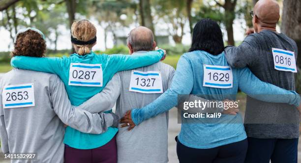 backs of five close friends ready to run a race - sporthesje stockfoto's en -beelden