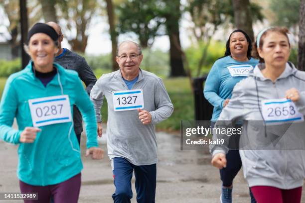 multiracial mature and senior adults running in race - marathon florida stockfoto's en -beelden