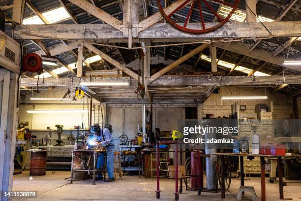 senior farmer ww2 navy veteran welding in his shop - in flames i the mask stock pictures, royalty-free photos & images