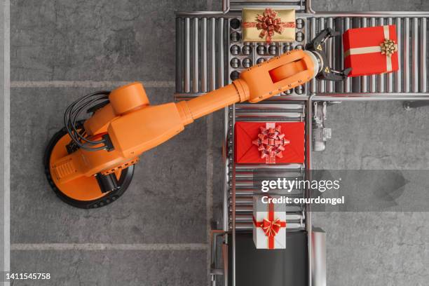 top view of robotic arm and gift boxes on conveyor belt - retail innovation stock pictures, royalty-free photos & images