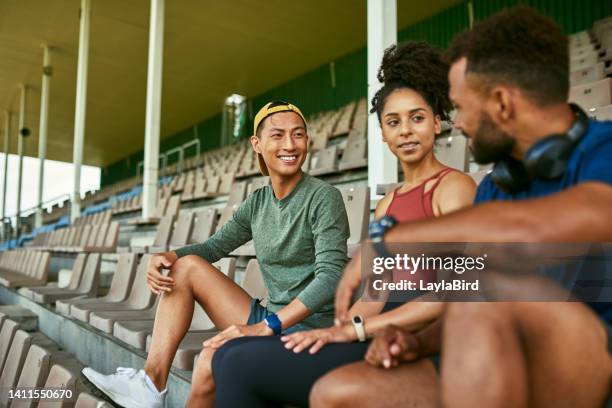 group of confident athletes taking a break in a sports stadium outdoors. diverse, motivated and fit young people hanging out and talking about ideas for training plans together as a dedicated team - liberty stadion stock pictures, royalty-free photos & images