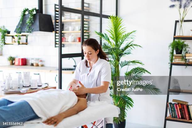 cosmetólogo haciendo masaje facial en casa - man made space fotografías e imágenes de stock