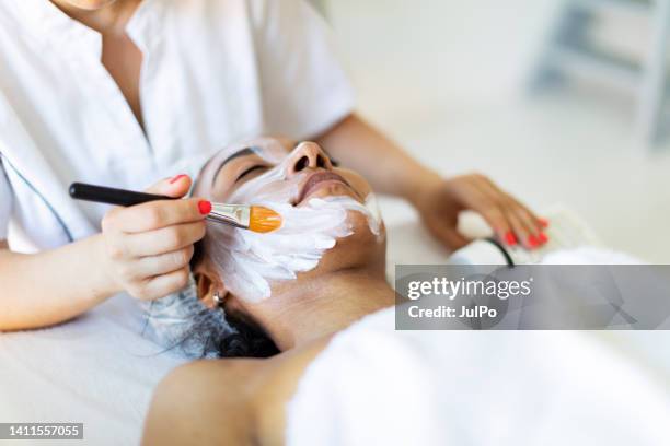 cosmetólogo haciendo masaje facial en casa - massage room fotografías e imágenes de stock