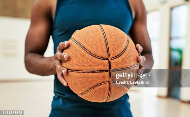 an african american basketball player ready for an active match. closeup of a fit and talented male athlete about to shoot hoops at training in a sports club. a young active man enjoying his hobby - muscle black wallpaper stock pictures, royalty-free photos & images