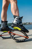 female trainer doing exercises jumping in the Kangoo jumps boots
