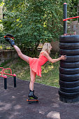 female trainer training kangoo jumping near street simulators