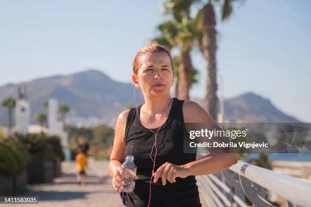 tired fit woman taking a break during a workout - squinting stock pictures, royalty-free photos & images