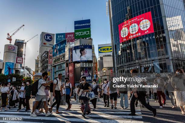 People wearing face masks cross Shibuya crossing on July 29, 2022 in Tokyo, Japan. The World Health Organization announced that Japan's COVID-19...