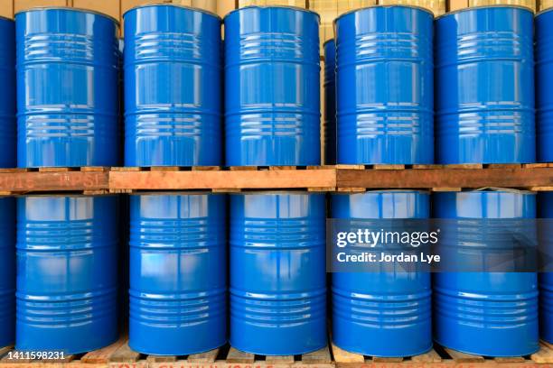 blue metal oil barrels stacked in a drumming room - galón fotografías e imágenes de stock