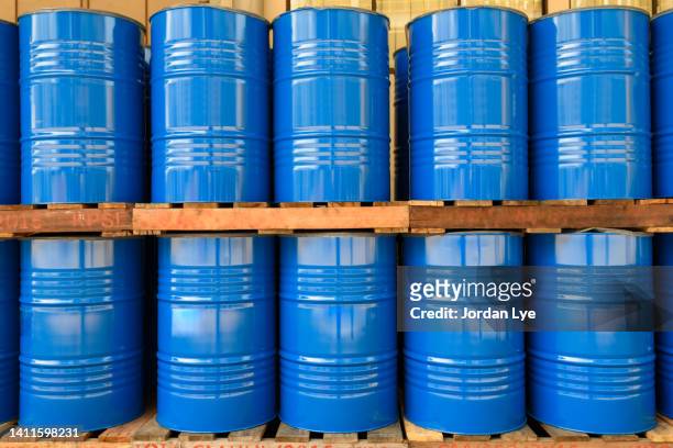 blue metal oil barrels stacked in a drumming room - gallon stock pictures, royalty-free photos & images
