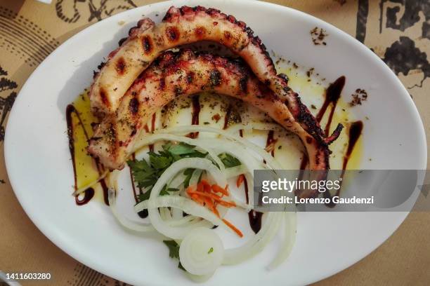 grilled octopus garnished with onions and vegetables - thessaloniki greece stock pictures, royalty-free photos & images