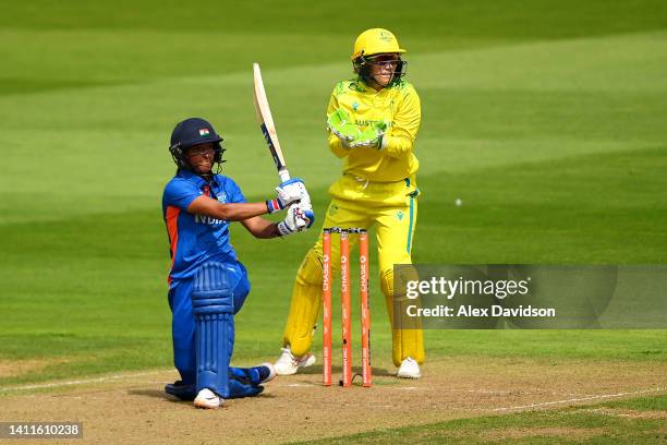 Harmanpreet Kaur of Team India hits out as Alyssa Healy of Team Australia watches on during the Cricket T20 Preliminary Round Group A match between...