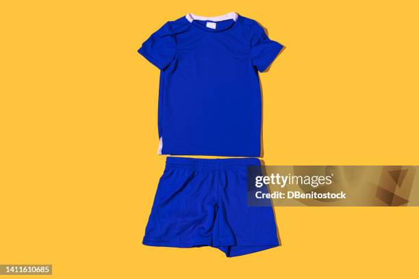 blue technical fabric soccer jersey and pants on a yellow background. concept of sport, soccer ball, uniform, world cup and kit. - vest stock pictures, royalty-free photos & images