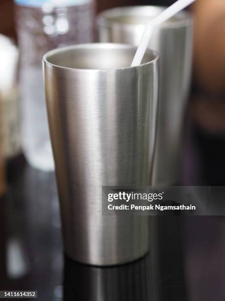stainless steel mug on black table - ステンレス ストックフォトと画像