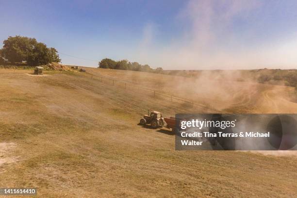 farmer spreading lime on his pasture with his tractor. view from above. - pawn chess piece stock-fotos und bilder