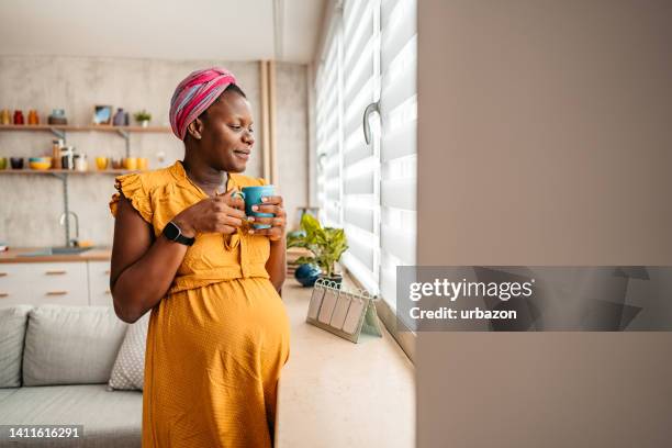 young pregnant woman drinking coffee at home - pregnant coffee 個照片及圖片檔