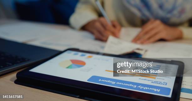 close up of young asian muslim woman with hijab using digital tablet check receipt monthly expense bill feeling unhappy stressed about debt problem in house at night. - low effort stock pictures, royalty-free photos & images