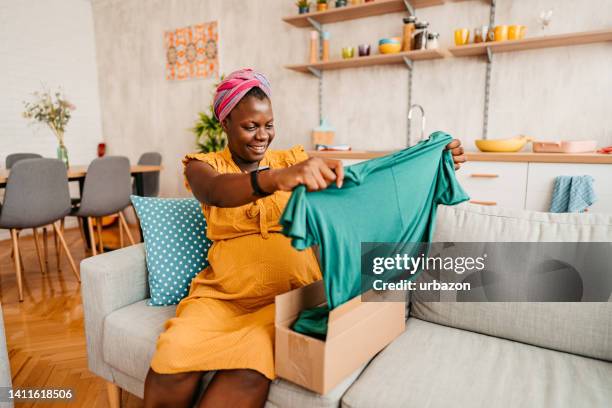 excited pregnant woman unpacking a box after online shopping - receiving package stock pictures, royalty-free photos & images