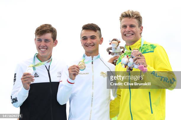 Silver medallist Hayden Wilde of Team New Zealand, Gold medallist Alex Yee of Team England and Matthew Hauser of Team Australia pose during the the...