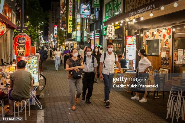 People wearing face masks walk through Ueno area on July 29, 2022 in Tokyo, Japan. World Health Organization announced Japan's COVID-19 cases between...