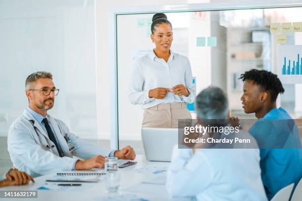 group of diverse doctors talking about new medical practices in a meeting at work. surgeons trying to find a diagnosis for disease at a clinic. healthcare workers discussing surgery statistics - penn commercial business stock pictures, royalty-free photos & images