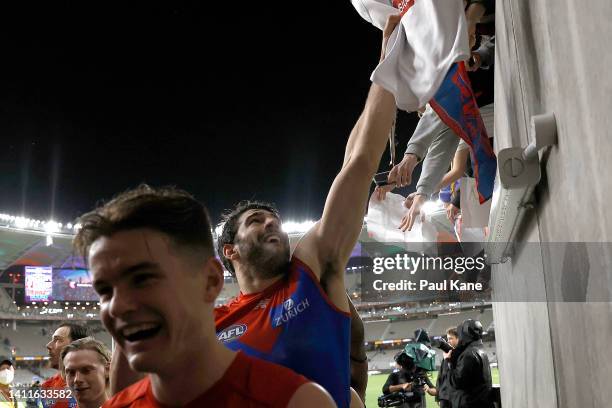Christian Petracca of the Demons snatches a Dockers top from a supporter while walking from field after winning the round 20 AFL match between the...